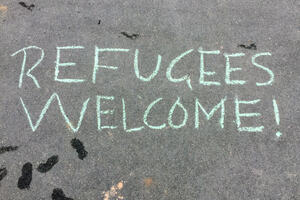 Chalk writing on the floor saying "Refugees Welcome!"